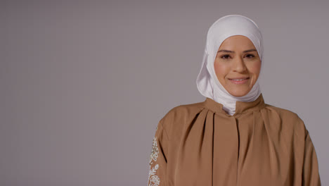 Studioporträt-Einer-Lächelnden-Muslimischen-Frau-Mit-Hijab-Vor-Schlichtem-Hintergrund-3